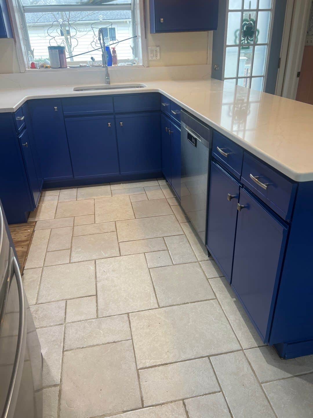 Vibrant Blue Kitchen Cabinet Painting Transformation Stunning kitchen featuring bold blue painted cabinets, sleek white quartz countertops, and light tile flooring.