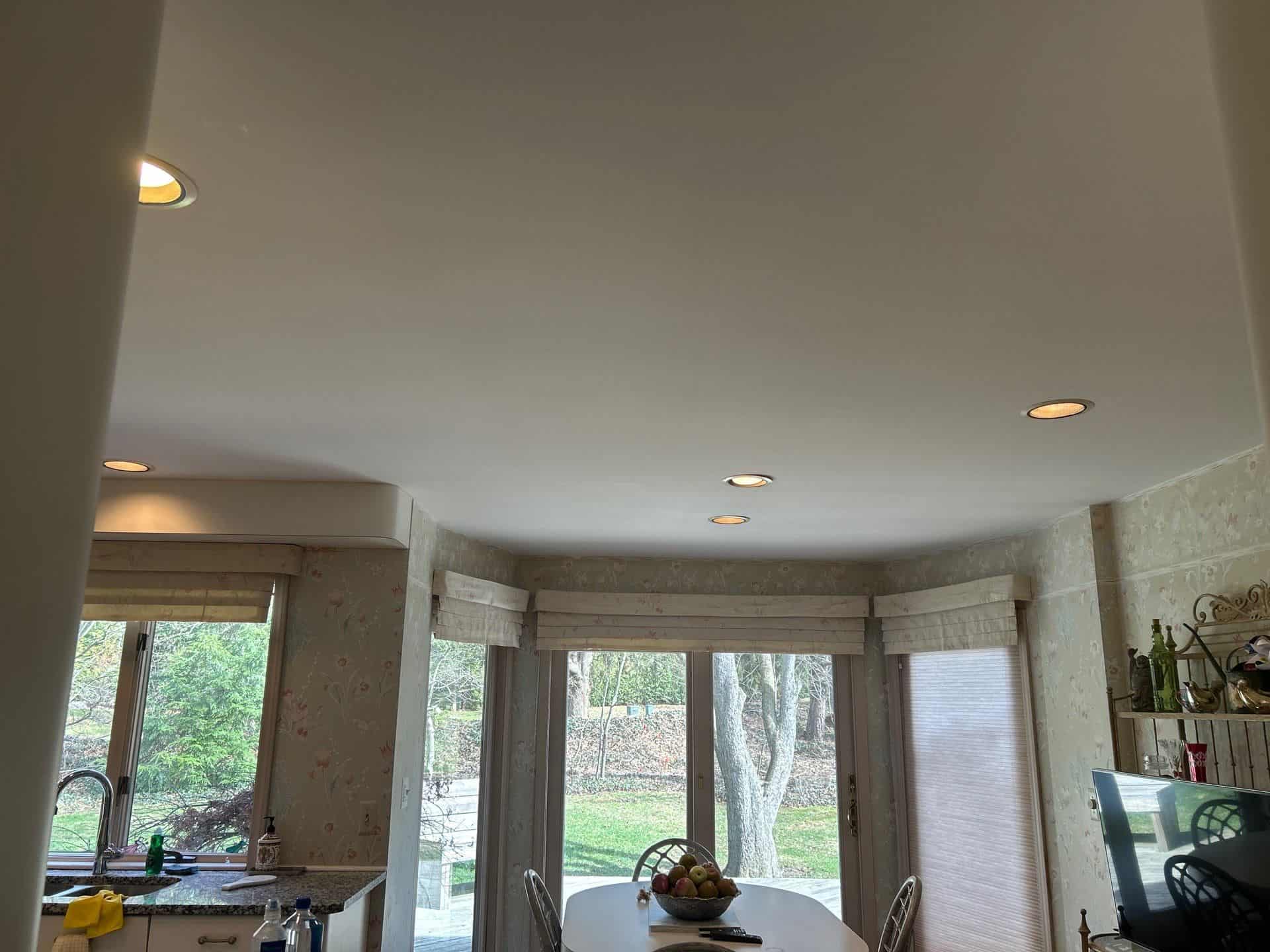 A cozy bedroom with light beige walls, a unique sloped ceiling, and a comfortable bed setup.