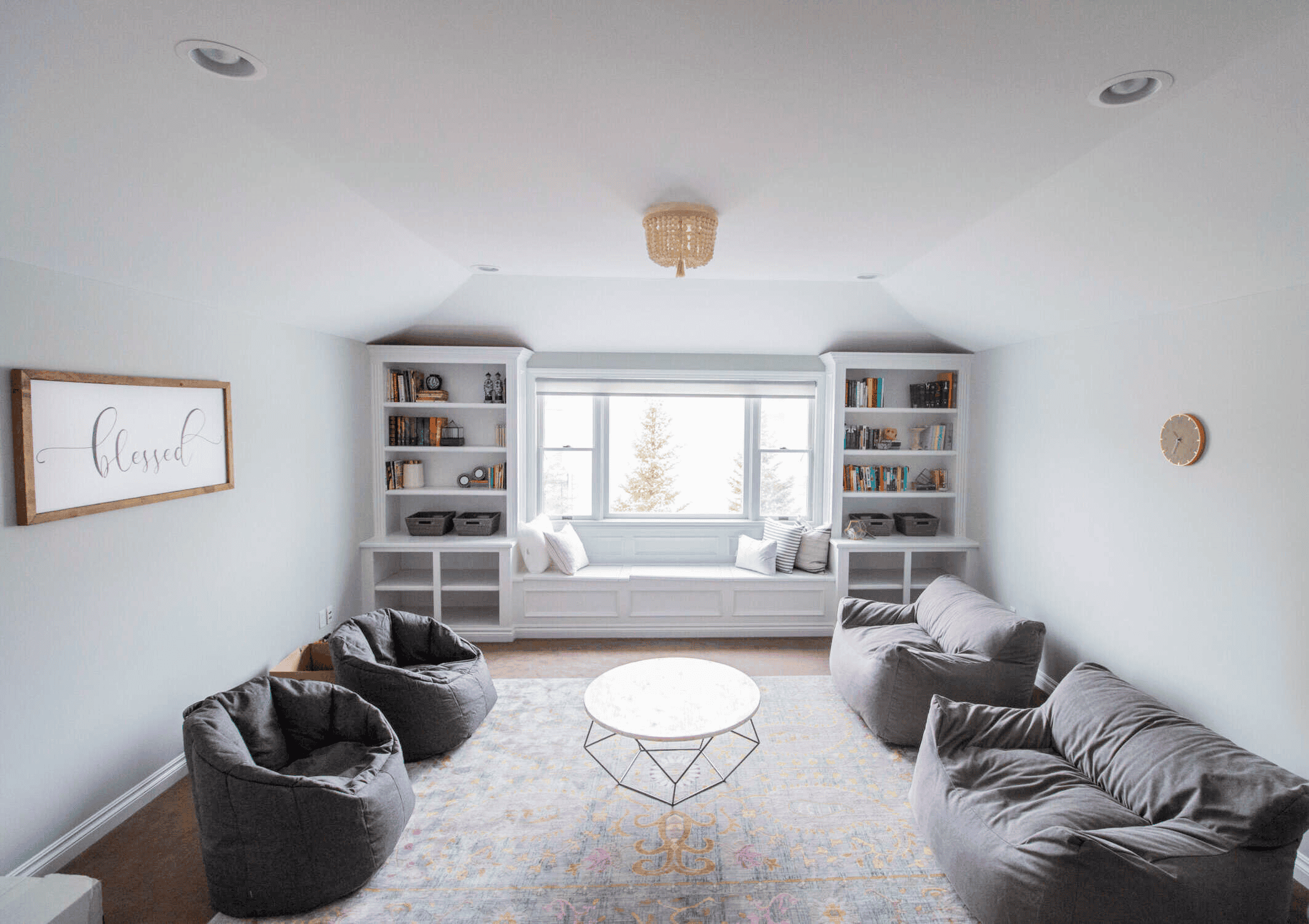 A freshly painted bright living room with light green walls, white trim, and built in bookshelves.