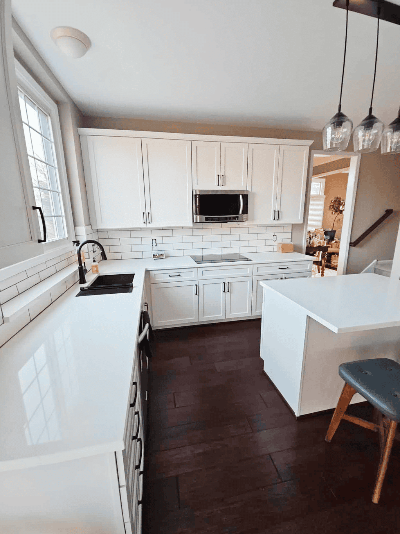 A modern kitchen with freshly painted tan walls, white cabinets, and a white subway tile backsplash.