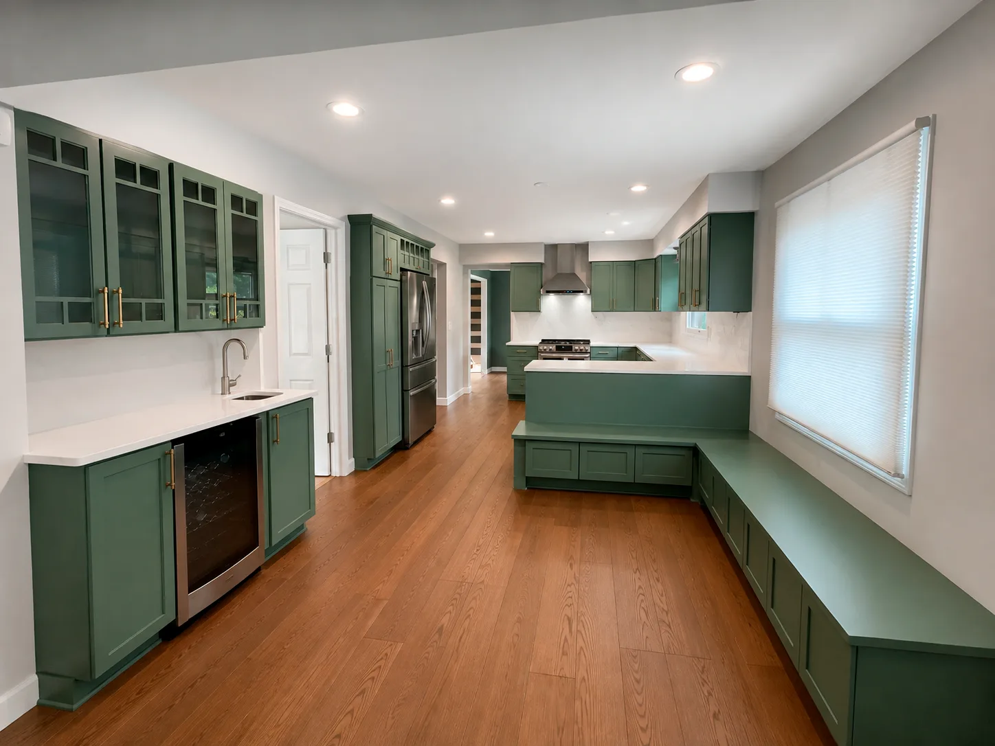 Forest Green Kitchen Cabinets Forest green-painted kitchen cabinets with glass upper doors, brass hardware, white quartz countertop, and stainless