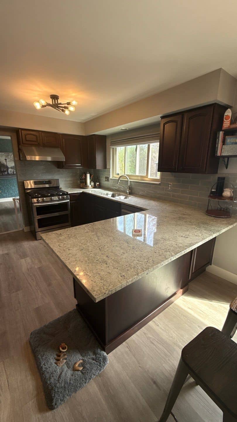 Dark Brown Kitchen Cabinets Before Dark brown wood kitchen cabinets with recessed panel doors, stainless steel appliances, speckled granite countertop, and