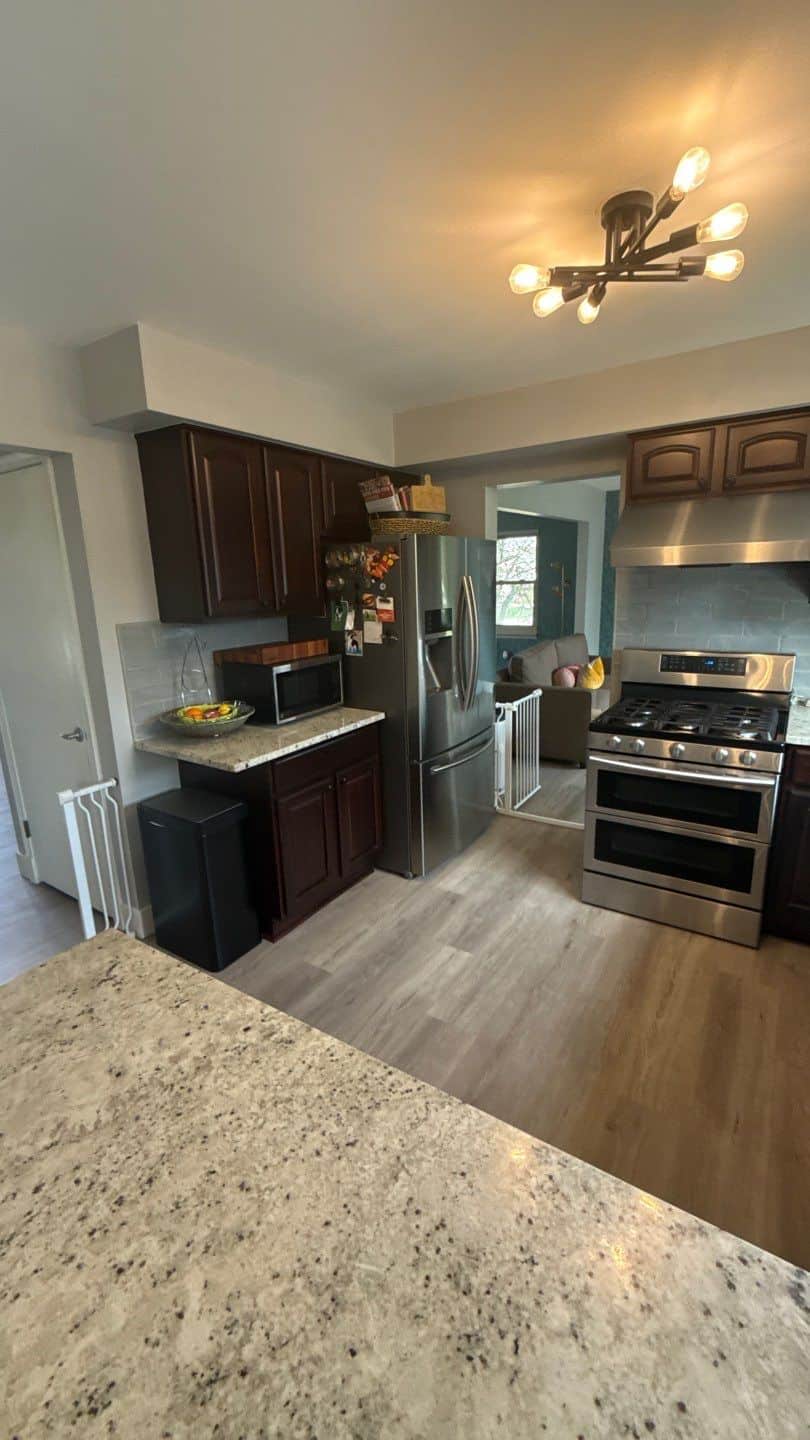 Dark Stained Kitchen Cabinets Before Dark brown stained kitchen cabinets with recessed panel doors, speckled granite countertop, and stainless steel appliances